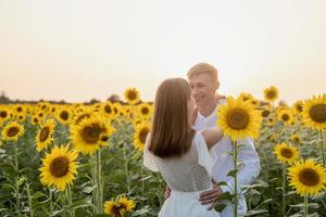 hermosa pareja divirtiéndose en campos de girasoles foto