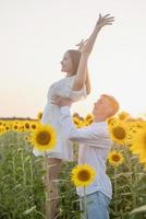 hermosa pareja divirtiéndose en campos de girasoles foto