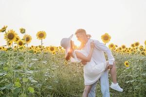 Beautiful couple having fun in sunflowers fields photo