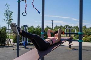 Deportiva mujer trabajando en el campo de deportes en un día soleado de verano foto