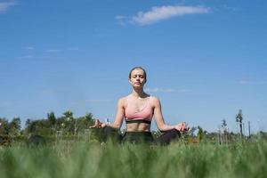 Sportive woman working out in the park in sunny summer day photo