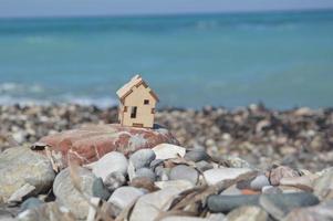 Small wooden mock-up of a house on the background of the sea photo