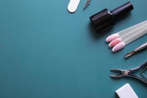 Manicure tools and tips on blue background with copy space photo