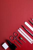 Manicure tools and tips on red background with copy space photo