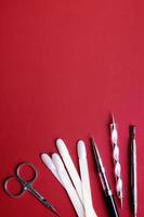 Manicure tools and tips for nail art on red background with copy space. Gel polish coating concept