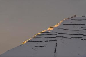 Avalanche barriers in the mountains at sunset photo