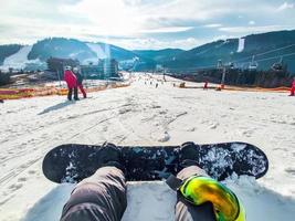 Snowboarding concept sitting on the hill people skiing down photo