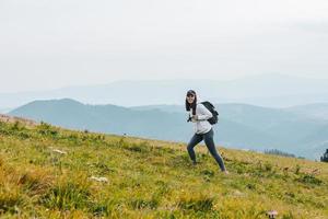 Woman with backpack hiking in mountains photo