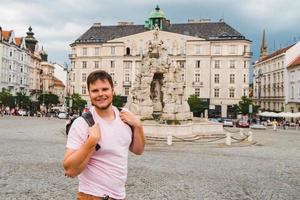 Hombre viajero en la plaza turística en la vieja ciudad europea foto