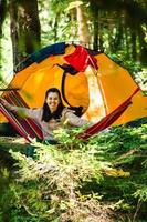 Woman laying down in hammock in the forest tent on background photo