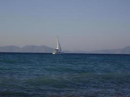 Un velero navega en el mar Egeo a lo largo de la isla de Rodas en Grecia foto