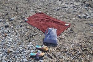 Beach slippers with a bag lie on stones photo