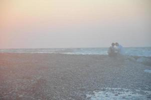 pareja joven, abrazar, en, ocaso, en, el, mar egeo, en, grecia foto