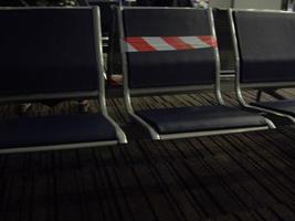 asientos en el aeropuerto internacional que indican la distancia entre los pasajeros foto
