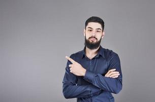 Cheerful handsome man showing direction and pointing with finger photo