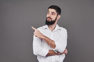 Cheerful handsome man showing direction and pointing with finger photo