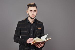 Portrait of toothy handsome bearded man with book on hands photo