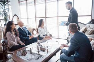 Young team of coworkers making great business discussion in modern coworking office. Teamwork people concept photo