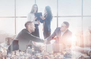 Young team of coworkers making great business discussion in modern coworking office. Teamwork people concept. Double exposition, panorama of modern city photo