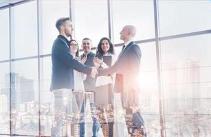 Two confident business man shaking hands during a meeting in the office, success, dealing, greeting and partner concept photo