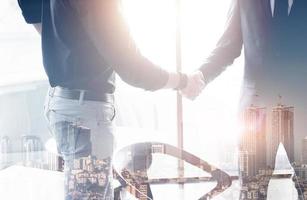 Two confident business man shaking hands during a meeting in the office, success, dealing, greeting and partner concept. photo