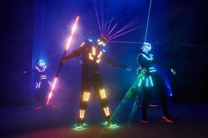 Laser show performance, dancers in led suits with LED lamp, very beautiful night club performance, party photo