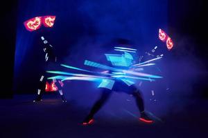 Laser show performance, dancers in led suits with LED lamp, very beautiful night club performance, party photo