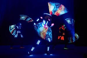 Laser show performance, dancers in led suits with LED lamp, very beautiful night club performance, party photo