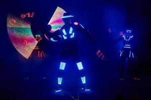 Laser show performance, dancers in led suits with LED lamp, very beautiful night club performance, party photo