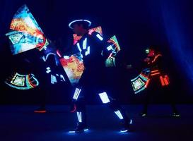 Laser show performance, dancers in led suits with LED lamp, very beautiful night club performance, party photo