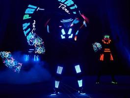 Laser show performance, dancers in led suits with LED lamp, very beautiful night club performance, party photo