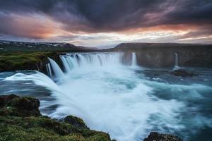 la pintoresca puesta de sol sobre paisajes y cascadas. montaña kirkjufell, islandia foto