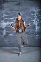 Young beautiful girl dancing in a trendy clothes on a grunge background photo