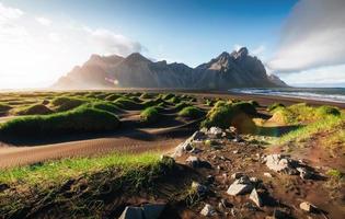 Fantastic west of the mountains and volcanic lava sand dunes on the beach Stokksness, Iceland. Colorful summer morning Iceland, Europe photo