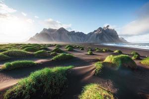 Fantastic west of the mountains and volcanic lava sand dunes on the beach Stokksness, Iceland. Colorful summer morning Iceland, Europe