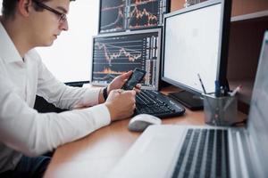 corredor de bolsa en camisa está trabajando en una sala de vigilancia con pantallas de visualización. concepto gráfico de las finanzas de la divisa del comercio de la bolsa de valores. empresarios negociando acciones online foto