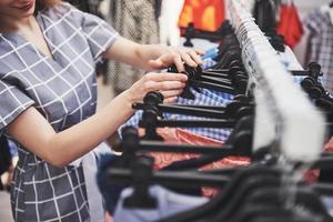 Hermosas mujeres jóvenes en el mercado semanal de telas: mejores amigas compartiendo tiempo libre divirtiéndose y comprando foto