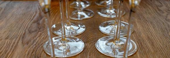 Two rows of wine glasses on a wooden table photo