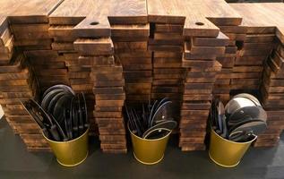 Montón de tablas de cortar de madera, cubos de metal con cortadores para pizza foto