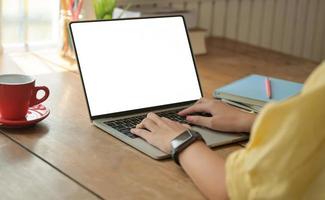 Cropped shot of A girl typing laptop keyboard on a desk with coffee cup , She works at home, Shot Taken from the back. photo