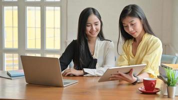 dos mujeres asiáticas con laptop y tableta trabajando en casa. para prevenir la propagación del coronavirus.