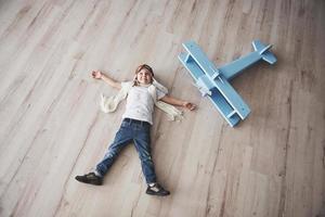 Child pretend to be pilot. Kid having fun at home. Summer vacation and travel concept. Top view portrait photo