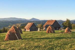 pajar en la puesta del sol. prado, pedazo de pastizal, especialmente uno usado para heno. montañas de los cárpatos, ucrania foto