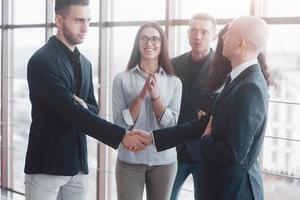 Two confident business man shaking hands during a meeting in the office, success, dealing, greeting and partner concept photo