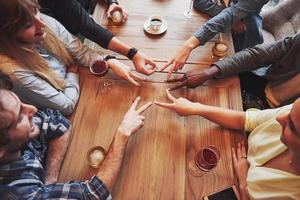 Close up top view of young people putting their hands together. Friends Doing a Star Shape with fingers showing unity and teamwork photo