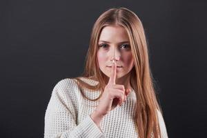 Close up portrait of beautiful young woman in white sweater and jeans, isolated on black background photo