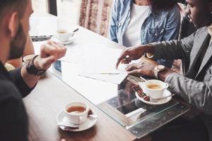 grupo de empresarios vestidos casualmente discutiendo ideas. profesionales creativos se reunieron para discutir los temas importantes del nuevo proyecto de inicio exitoso. concepto de lluvia de ideas de trabajo en equipo foto