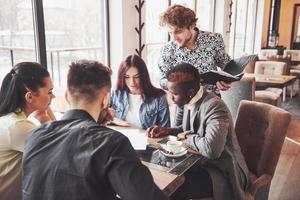 grupo de empresarios vestidos casualmente discutiendo ideas. profesionales creativos se reunieron para discutir los temas importantes del nuevo proyecto de inicio exitoso. concepto de lluvia de ideas de trabajo en equipo foto