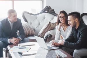 Young team of coworkers making great business discussion in modern coworking office. Teamwork people concept photo