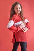 Joven mujer urbana bailando sobre fondo rojo, moderno estilo hip-hop delgado adolescente